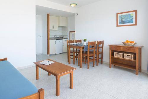 cocina y comedor con mesa y sillas en Magalluf Strip Apartment, en Magaluf