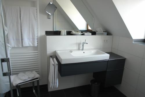La salle de bains est pourvue d'un lavabo et d'un miroir. dans l'établissement Hotel Kallstadter Hof, à Kallstadt