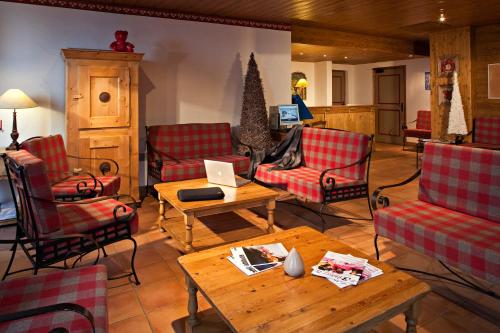 - un salon avec des chaises et une table avec un ordinateur portable dans l'établissement CGH Résidences & Spas les Chalets du Soleil Authentiques, aux Menuires