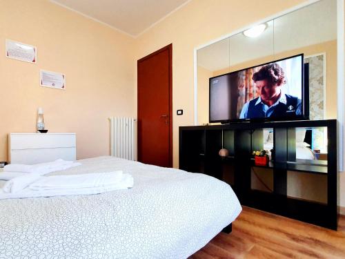 a bedroom with a bed and a flat screen tv at GUEST HOLIDAY GRAMSCI in Reggio Emilia