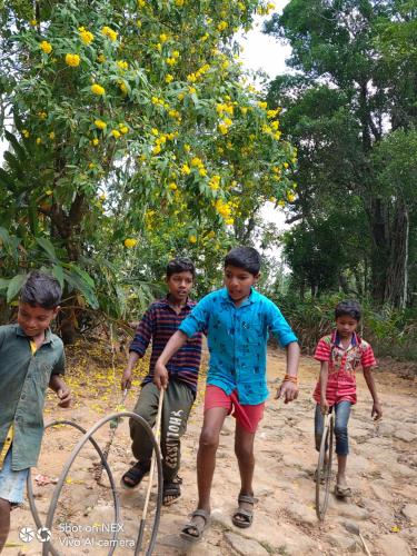a group of children riding bikes on a dirt road at Beyond Eco Living in Munnar