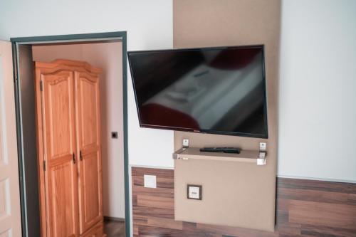 einen Flachbild-TV an einer Wand neben einer Tür in der Unterkunft SSC Sport+Seminarcenter Radevormwald in Radevormwald