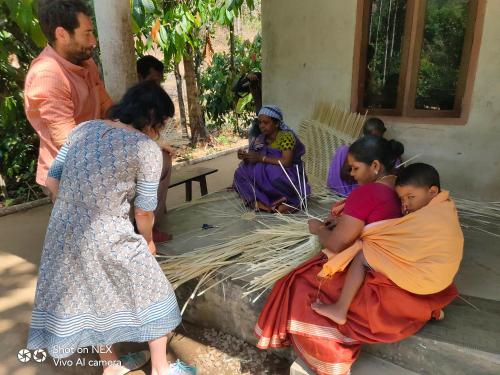 a group of women and children sitting outside a house at Beyond Eco Living in Munnar