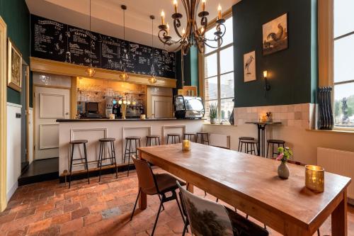 
a kitchen with a table, chairs, and a fireplace at Stayokay Hostel Domburg in Oostkapelle
