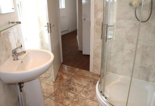 a bathroom with a sink and a shower at Cotswolds Valleys Accommodation - Bell Apartments - Exclusive use large two bedroom family holiday apartment in Stroud