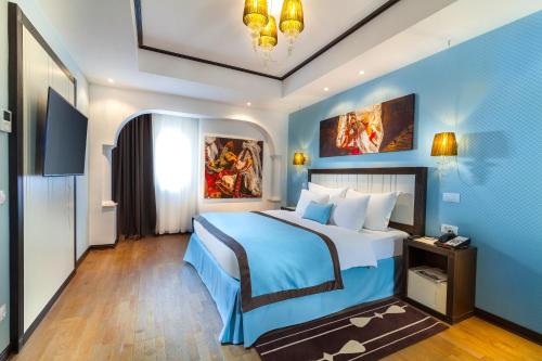 a bedroom with a large bed with blue walls at Epoque Hotel - Relais & Chateaux in Bucharest