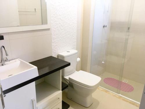 a bathroom with a toilet and a sink and a shower at Edifício Colinas in Piratuba