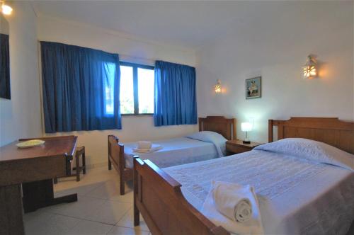 a hotel room with two beds and a desk at Solar dos Vilarinhos - By bedzy in Albufeira