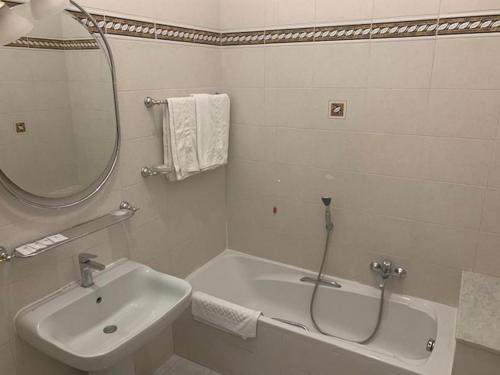 a bathroom with a tub and a sink and a mirror at Hotel Croce Di Malta in Rome