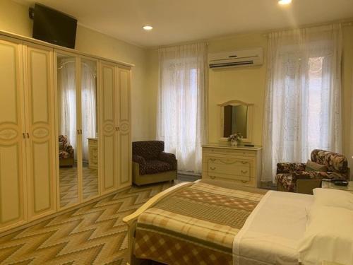 a bedroom with a bed and a chair and a mirror at Hotel Croce Di Malta in Rome