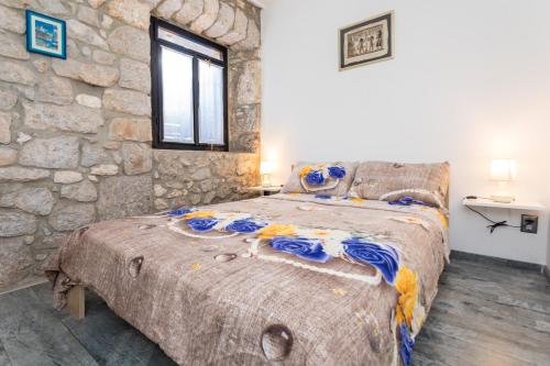 a bedroom with a large bed in a stone wall at Holiday Home Casa Bianca in Malinska
