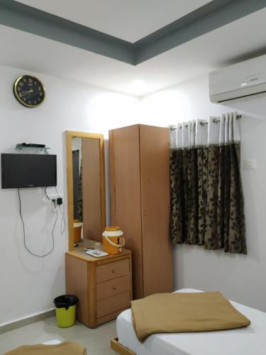 a bedroom with a bed and a dresser and a mirror at Hotel neptune in Amreli