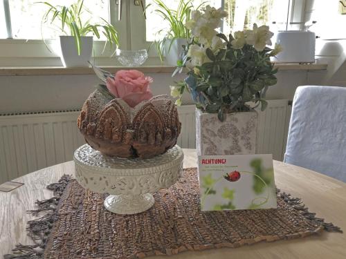 a table with two vases and a book and flowers at Ferienhaus mit Garten in Weißenbrunn in Weißenbrunn