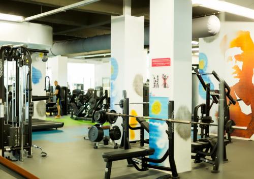 a gym with lots of tread machines and a wall at Caro Hotel in Bucharest