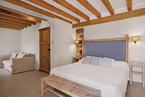 a bedroom with a large white bed and a couch at Hotel Es Port in Port de Soller