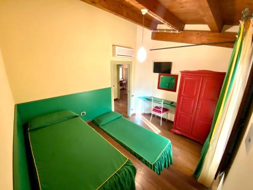 a room with a green bed and a red cabinet at Agriturismo Il Casale in Morrovalle