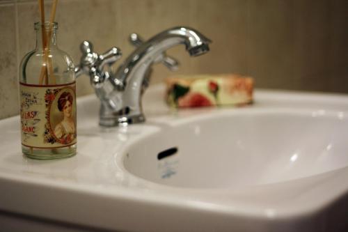 um lavatório de casa de banho com uma garrafa de álcool ao lado em Residenza Millennium em Florença