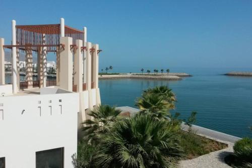 a view of the ocean from a building at NomadTours Marina Apartment Jebel Sifah in As Sīfah