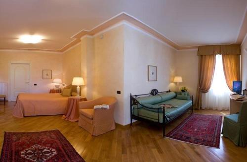 uma sala de estar com uma cama e um sofá e um quarto com em Albergo Castiglione Langhe em Castiglione Tinella