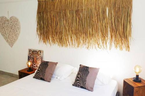 a bedroom with a white bed with two pillows at VILLA KADAL, perle rare à 50m du lagon… in La Saline les Bains