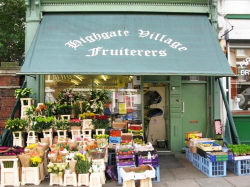 a store with a green awning with flowers and plants at Roseview Alexandra Palace Hotel in London