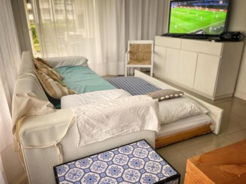 uma sala de estar com um sofá e uma televisão em Green Park Solanas Departamento en PB con Jardín y Parrillero em Punta del Este