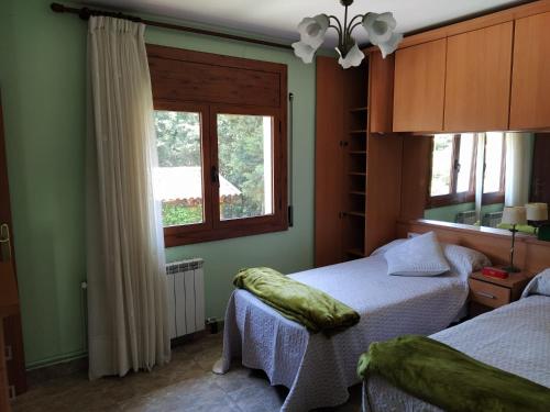 1 dormitorio con 2 camas y ventana en Casa en Parque Natural del Montseny., en Santa María de Palautordera