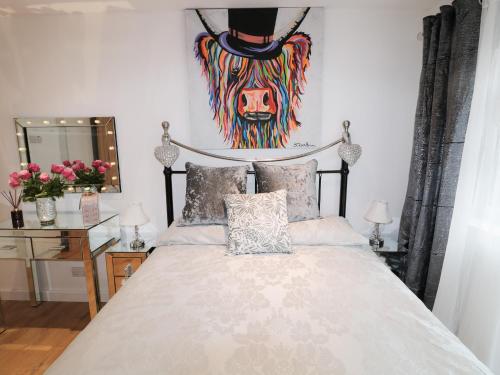 a bedroom with a bed and a painting on the wall at Swale Cottage in Chathill