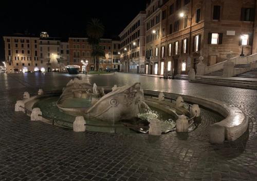 a fountain in the middle of a street at night at Hotel Croce Di Malta in Rome