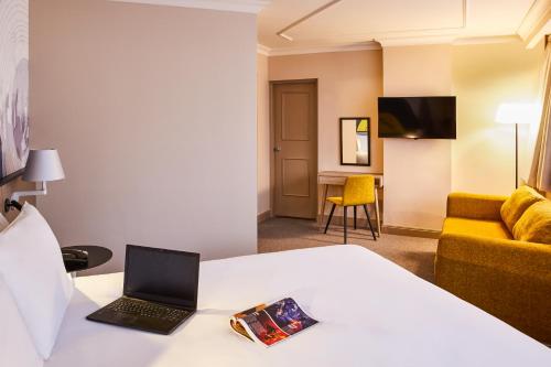 a living room filled with furniture and a laptop at Mercure Liverpool Atlantic Tower Hotel in Liverpool