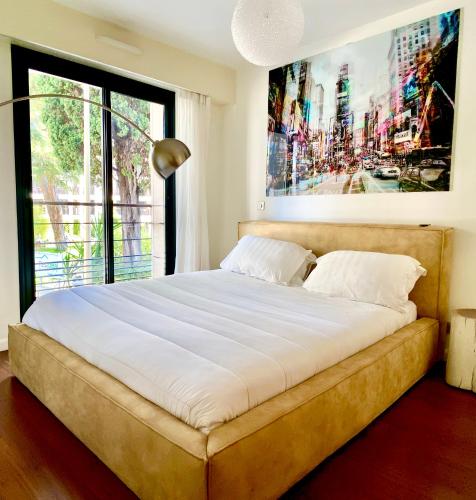 un grand lit dans une chambre avec une grande fenêtre dans l'établissement Carlton Riviera, à Cannes