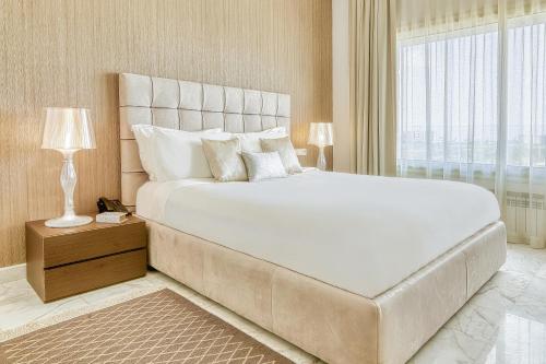 a large white bed in a room with a window at ADAM Hotel Suites in Tunis