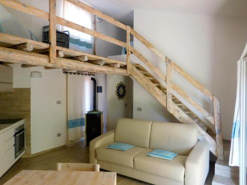 a living room with a loft bed and a couch at Residence La Pineta in Budoni