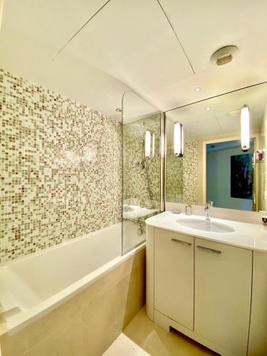 une salle de bain avec un lavabo, une douche et une baignoire dans l'établissement Carlton Riviera, à Cannes