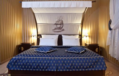 a bedroom with a bed with two blue pillows on it at Shuma in Dąbrowa Górnicza