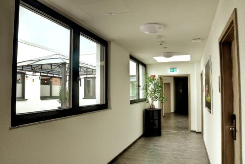 an empty hallway with windows in a building at Motel am Fürfelder Schloss in Bad Rappenau