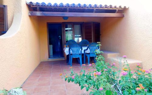 a patio with chairs and flowers in front of a house at Residence La Pineta in Budoni