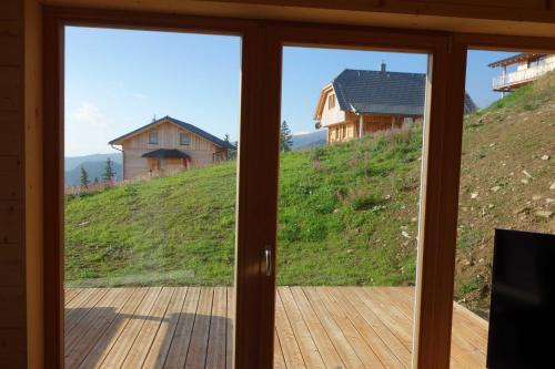 a sliding glass door with a view of a house at Ferienhaus Murmeltier am Klippitztörl in Klippitztorl