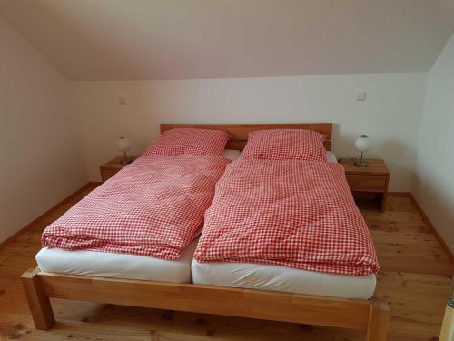a bedroom with two beds with red and white pillows at Ferienhaus Murmeltier am Klippitztörl in Klippitztorl
