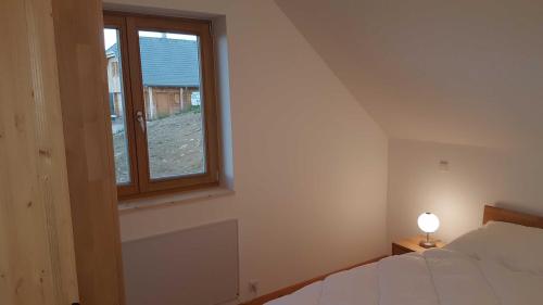 a bedroom with a bed and a window at Ferienhaus Murmeltier am Klippitztörl in Klippitztorl
