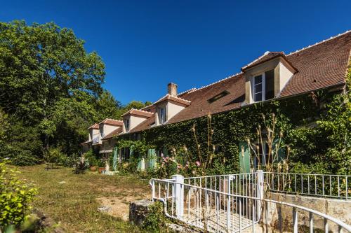 an ivy covered house with a white fence at Le Domaine des Carriers in Chevroches