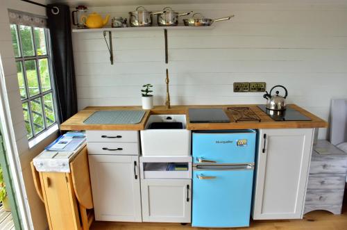 a small kitchen with a blue refrigerator and a counter at Castle Lodge in Sheriff Hutton