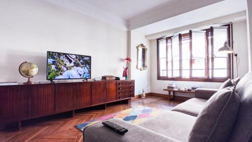 a living room with a couch and a flat screen tv at Spacious Confortable Next Beach and Pintxos Area in Donostia-San Sebastián