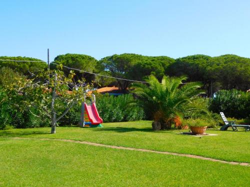 a garden with hammocks hanging from a rope at Residence La Pineta in Budoni
