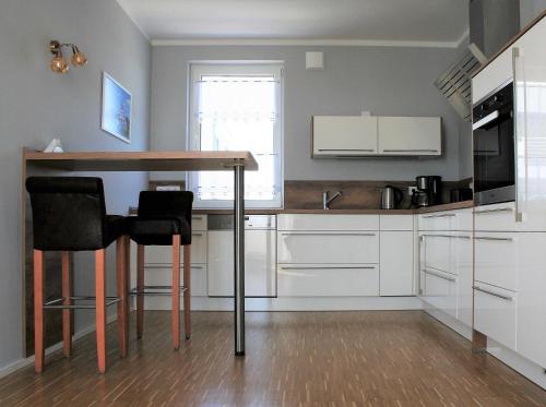 a kitchen with a table with two chairs and a sink at Ferienwohnung Penthaus ILSE in Großräschen