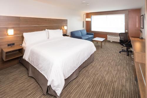 a hotel room with a large bed and a desk and chair at Holiday Inn Express & Suites - Kalamazoo West by IHG in Kalamazoo