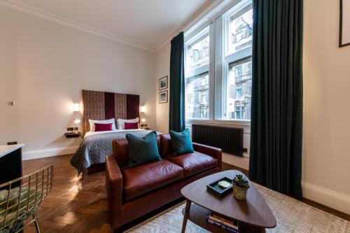 sala de estar con sofá, cama y ventana en Linton Collection - 28 North Bridge, en Edimburgo