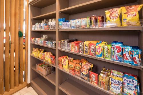 a store shelf filled with different types of chips at Holiday Inn Express & Suites - Kalamazoo West by IHG in Kalamazoo