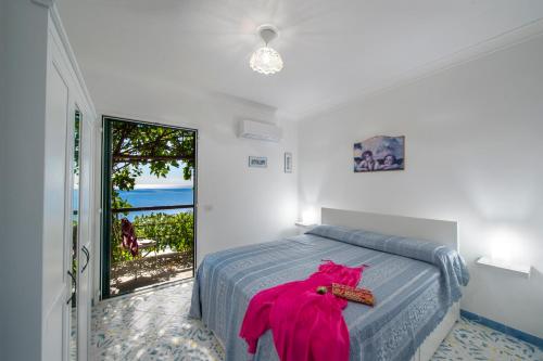 - une chambre avec un lit revêtu d'une robe rose dans l'établissement Sea Side Solandra, à Praiano