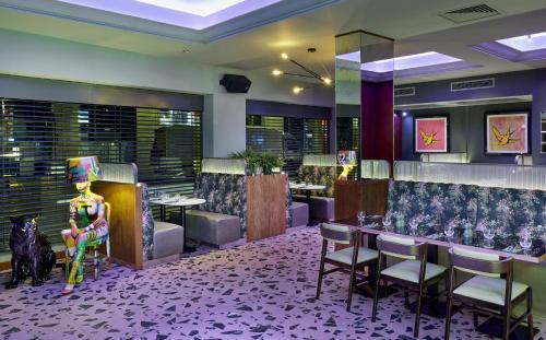 a restaurant with a bar with chairs and tables at NYX Hotel London Holborn by Leonardo Hotels in London